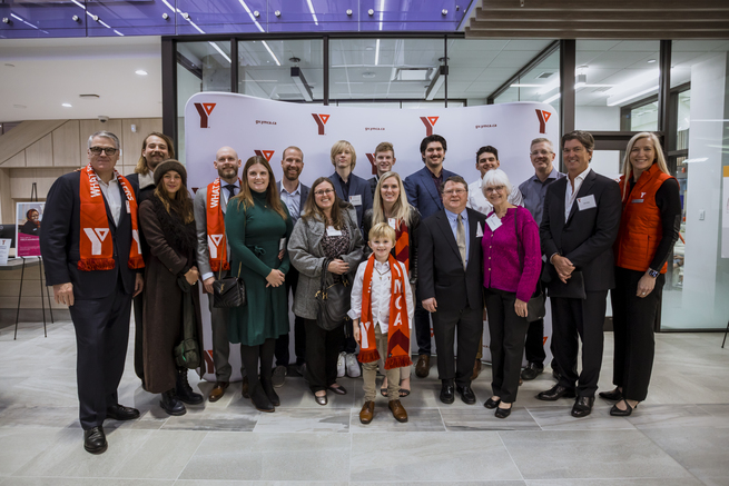 Sixteen members of the Allard family are joined by Greg D'Avignon and Heidi Worthington in the atrium of the Bettie Allard YMCA.
